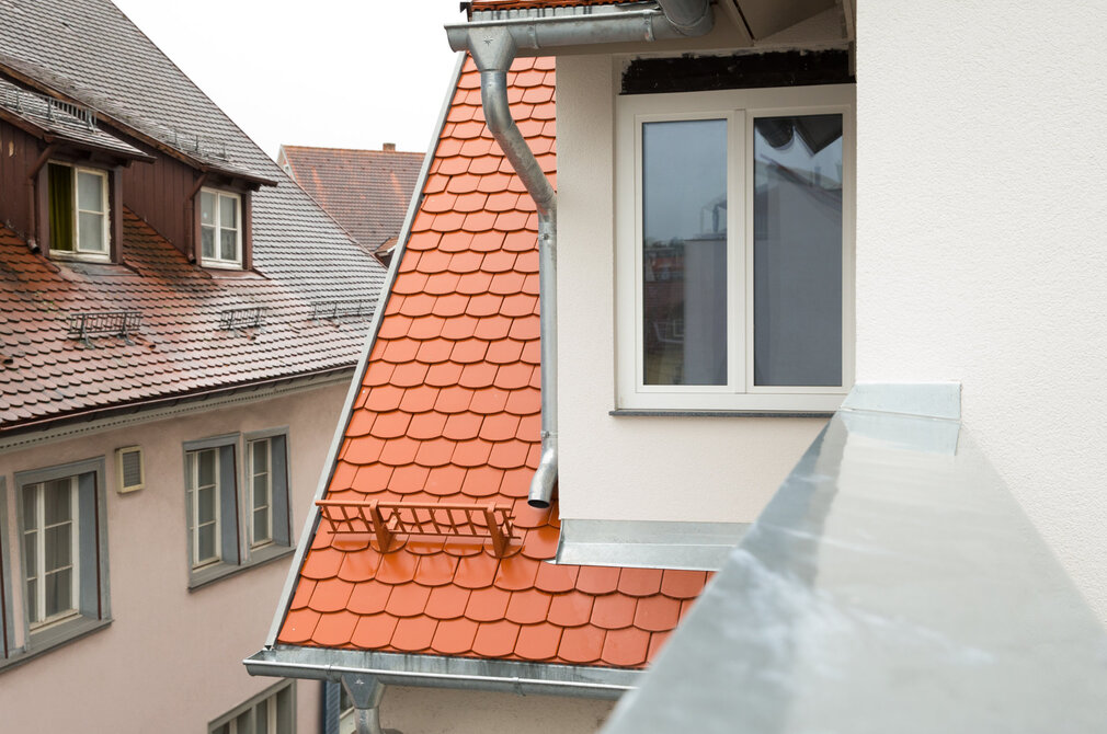 Dach mit roten Ziegeln und Blechen